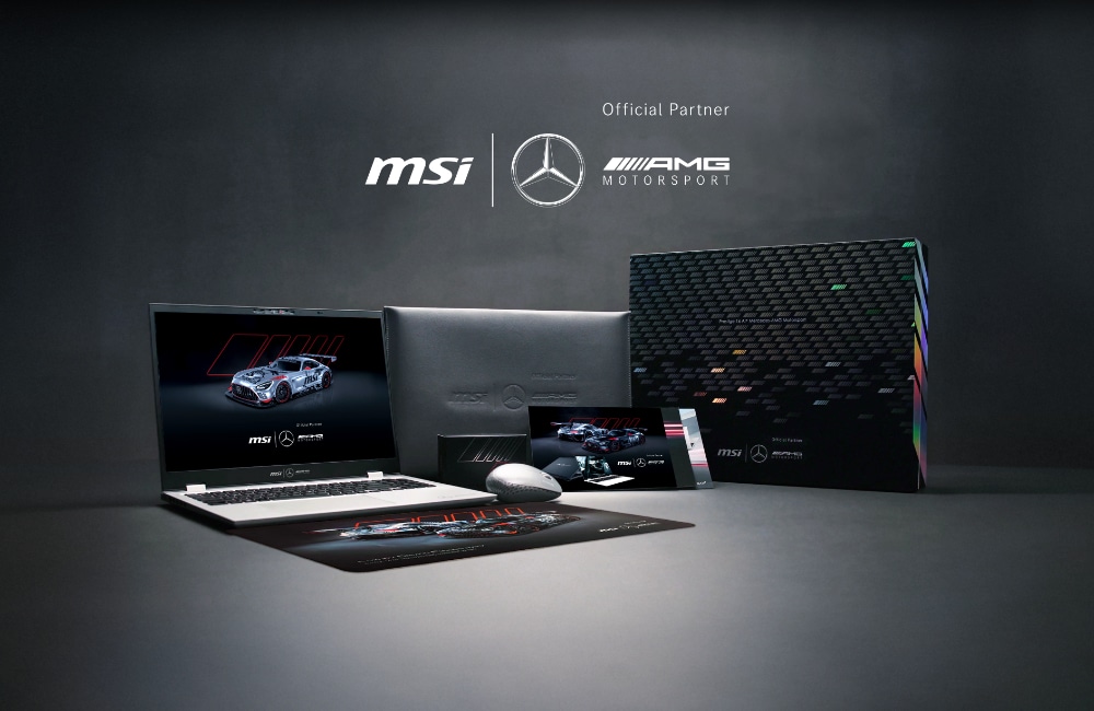 MSI Prestige 16 og Mercedes-AMG Motorsport laptop, mus, musemåtte, æske og tilbehør er arrangeret på en mørk overflade med partnerlogoer i baggrunden.