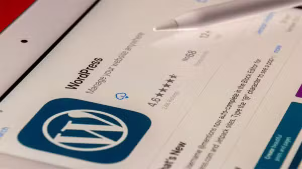 En tabletskærm viser WordPress' app-side i en app-butik med logo, bedømmelse og en stylus i nærheden - perfekt til FutureNode.dk-brugere, der udforsker nye digitale værktøjer.